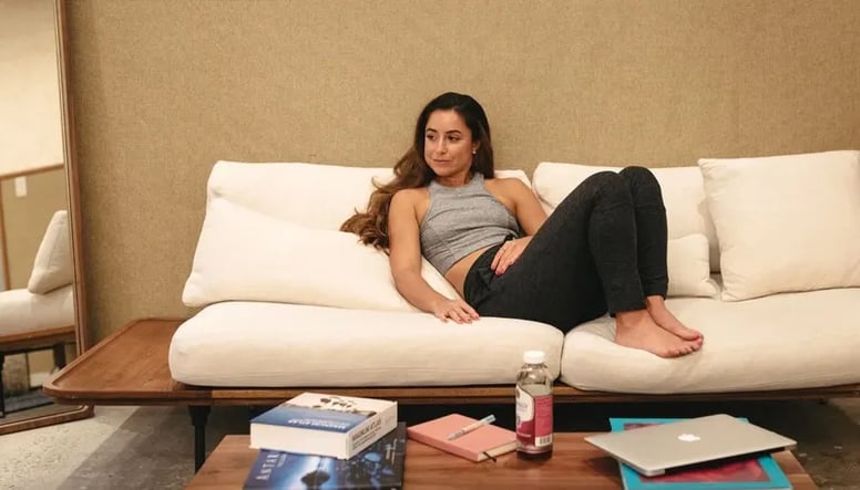 woman-lounging-on-white-couch-8-wfh-stretches-for-work-day